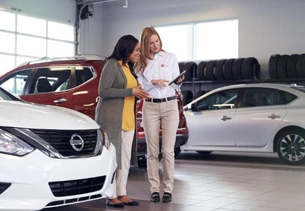 image of a man and a woman shaking hands beside a car