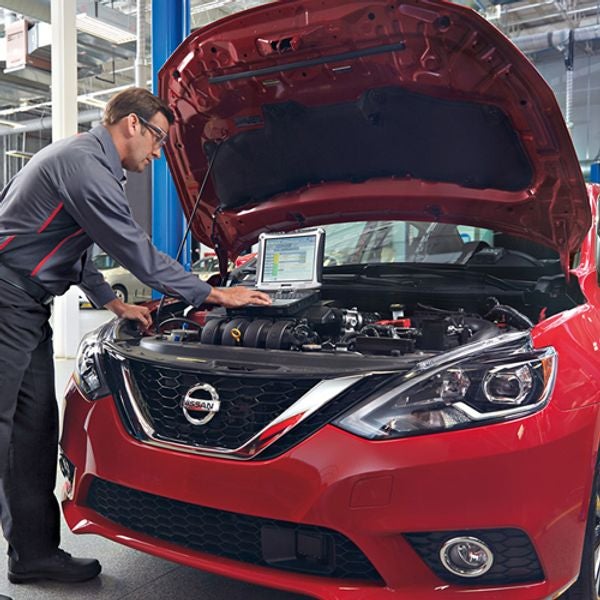 image of a man checking oil