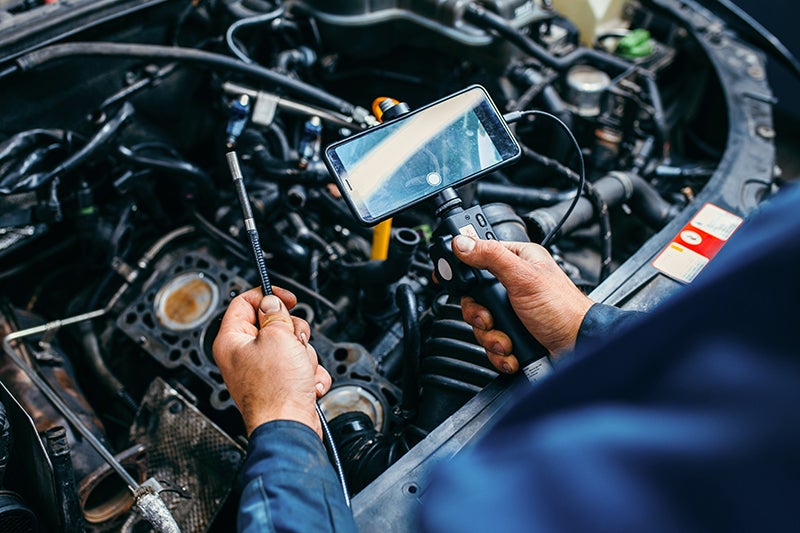 Technician holding some tools and servicing a engine